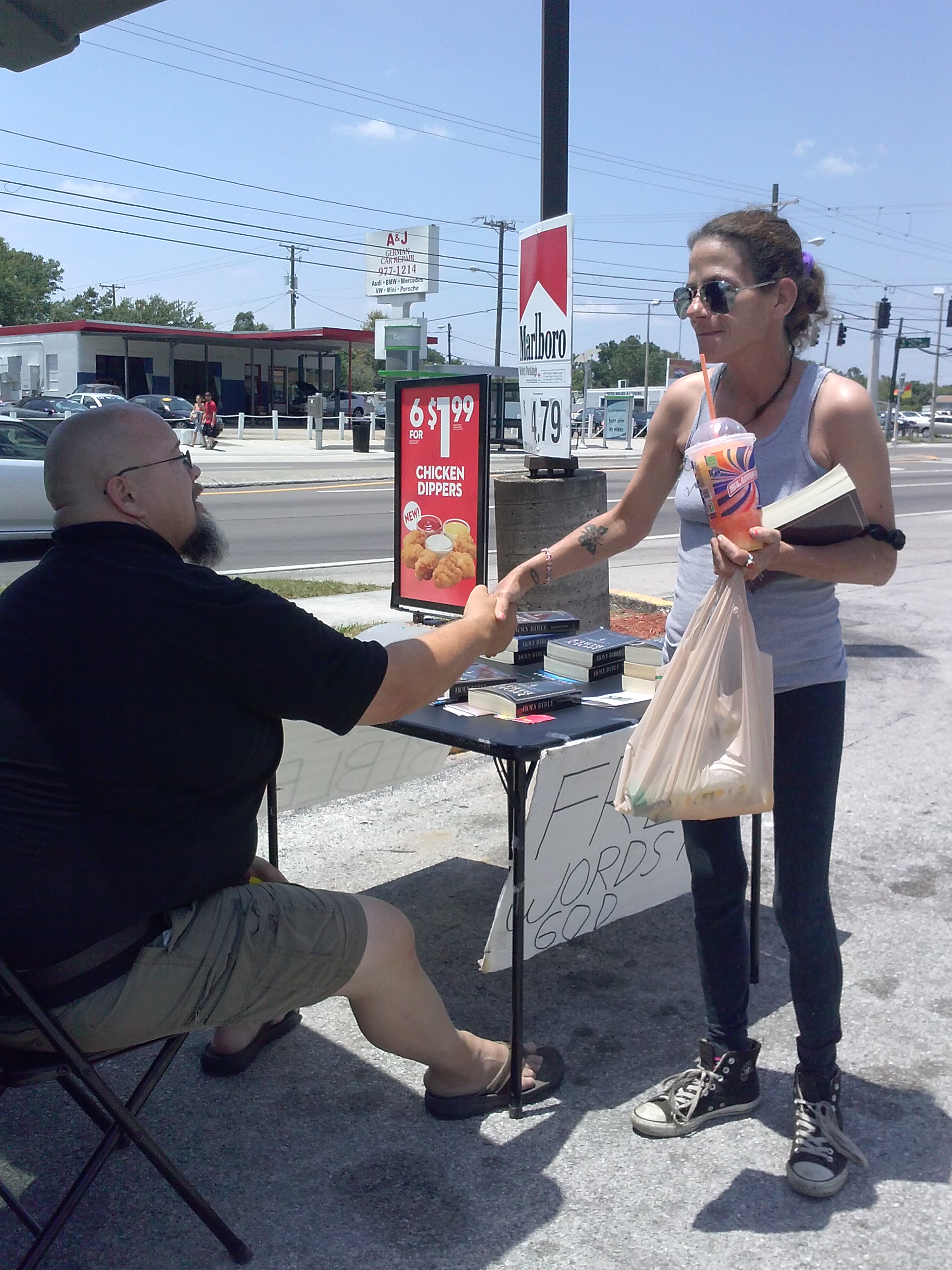 Woman getting a Bible at Nebraska Ave. table